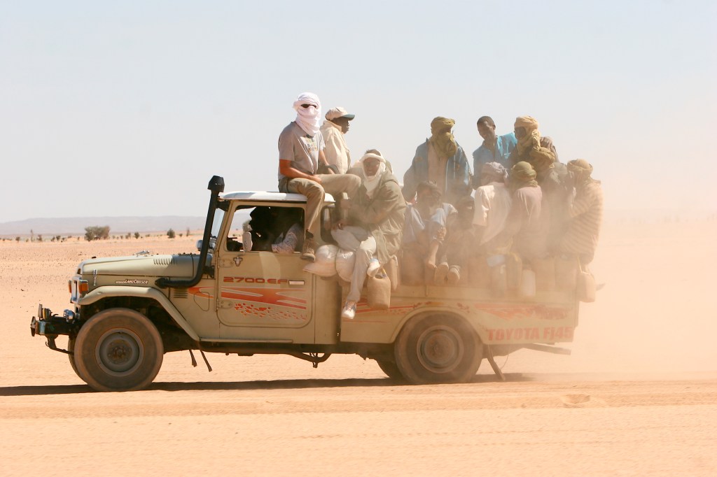 The reliability of the old Toyotas is seen here as a 70s Toyota FJ pickup carries men across the desert.