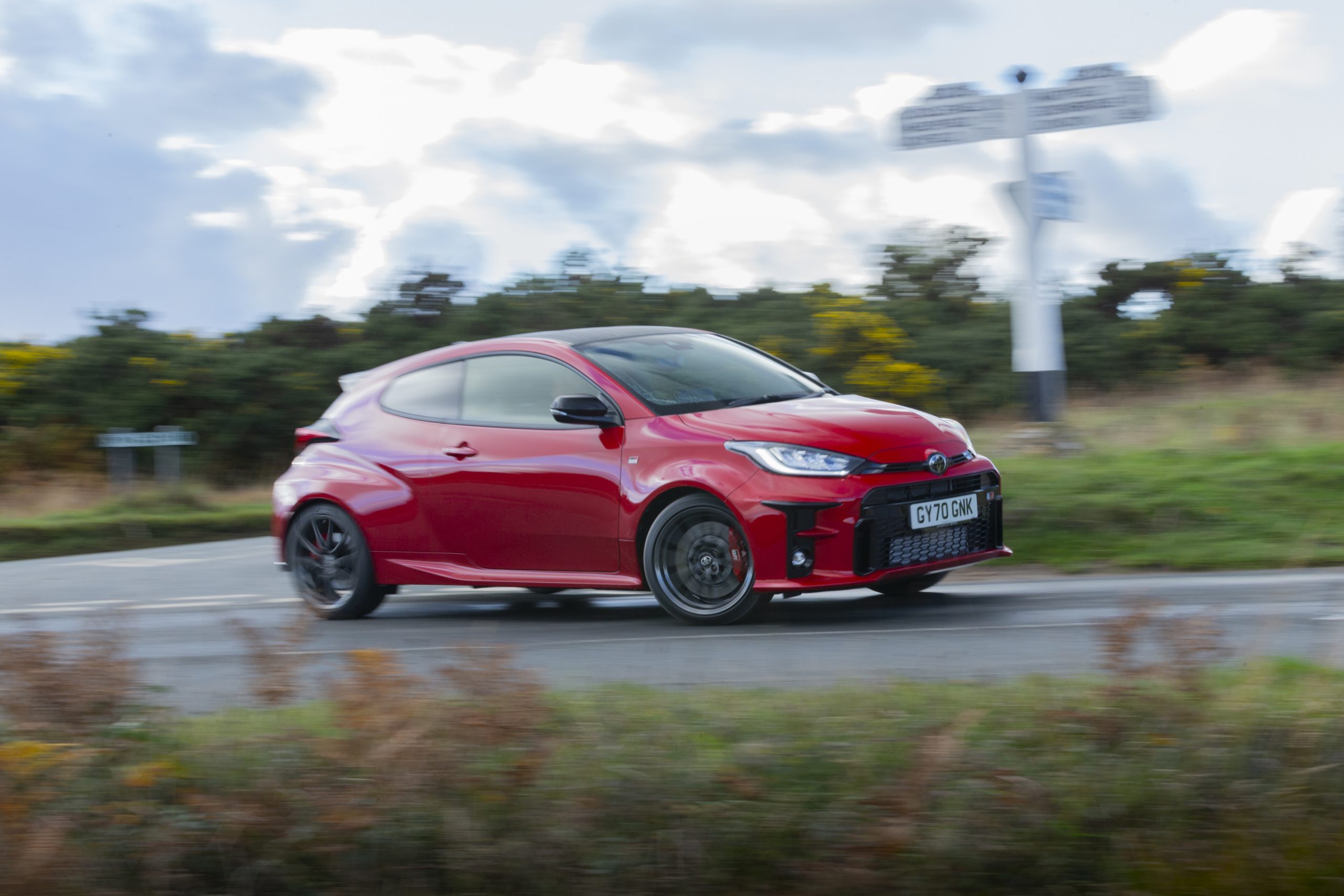 A red Toyota GR Yaris shot from the front 3/4 at speed