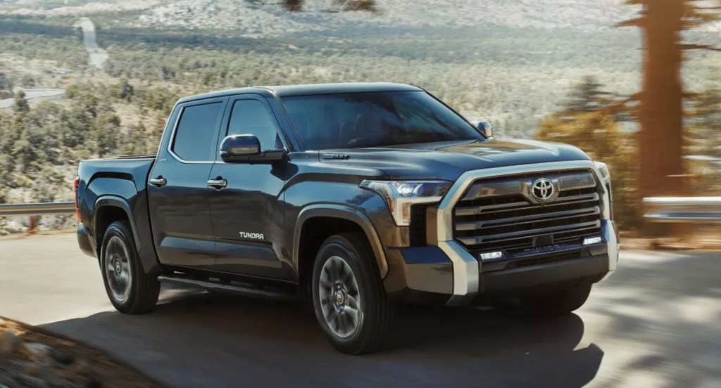 A black 2022 Toyota Tundra full-size pickup truck is driving on the road. 