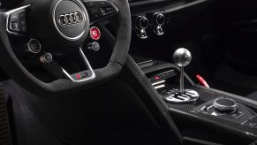The steering wheel and carbon-fiber center console of a 2020 Audi R8 Decennium with a gated manual shifter modified by Underground Racing