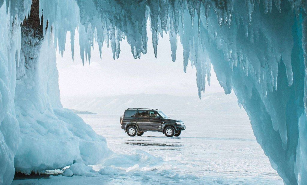 View of an SUV through an ice cave, highlighting article about how to start a car in cold weather