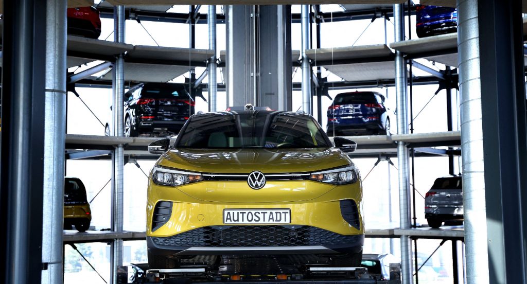 A yellow Volkswagen ID.4 is inside a Volkswagen auto tower. 