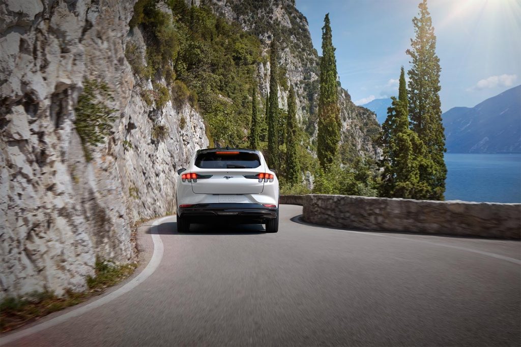 White 2022 Ford Mustang Mach-E driving near a lake