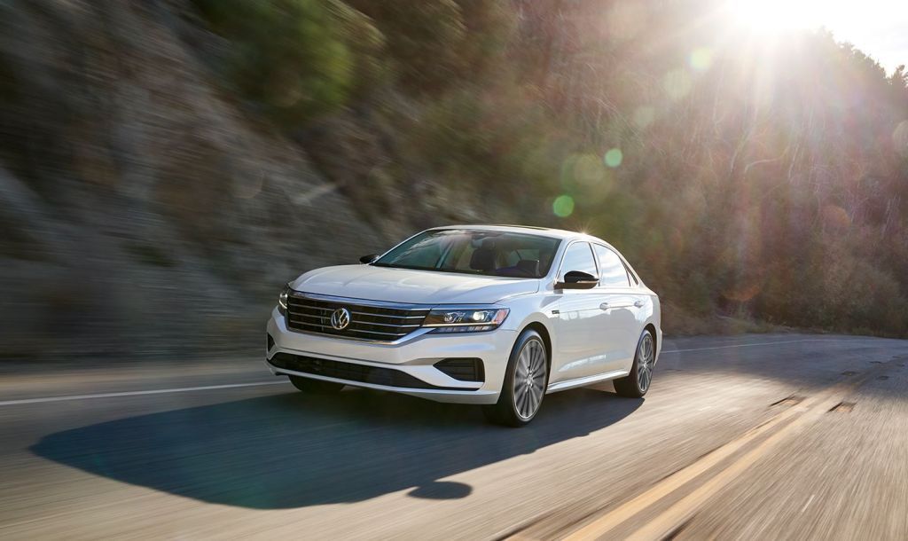 White 2022 VW Passat sedan, which Volkswagen killed off in all contries, driving by a forest