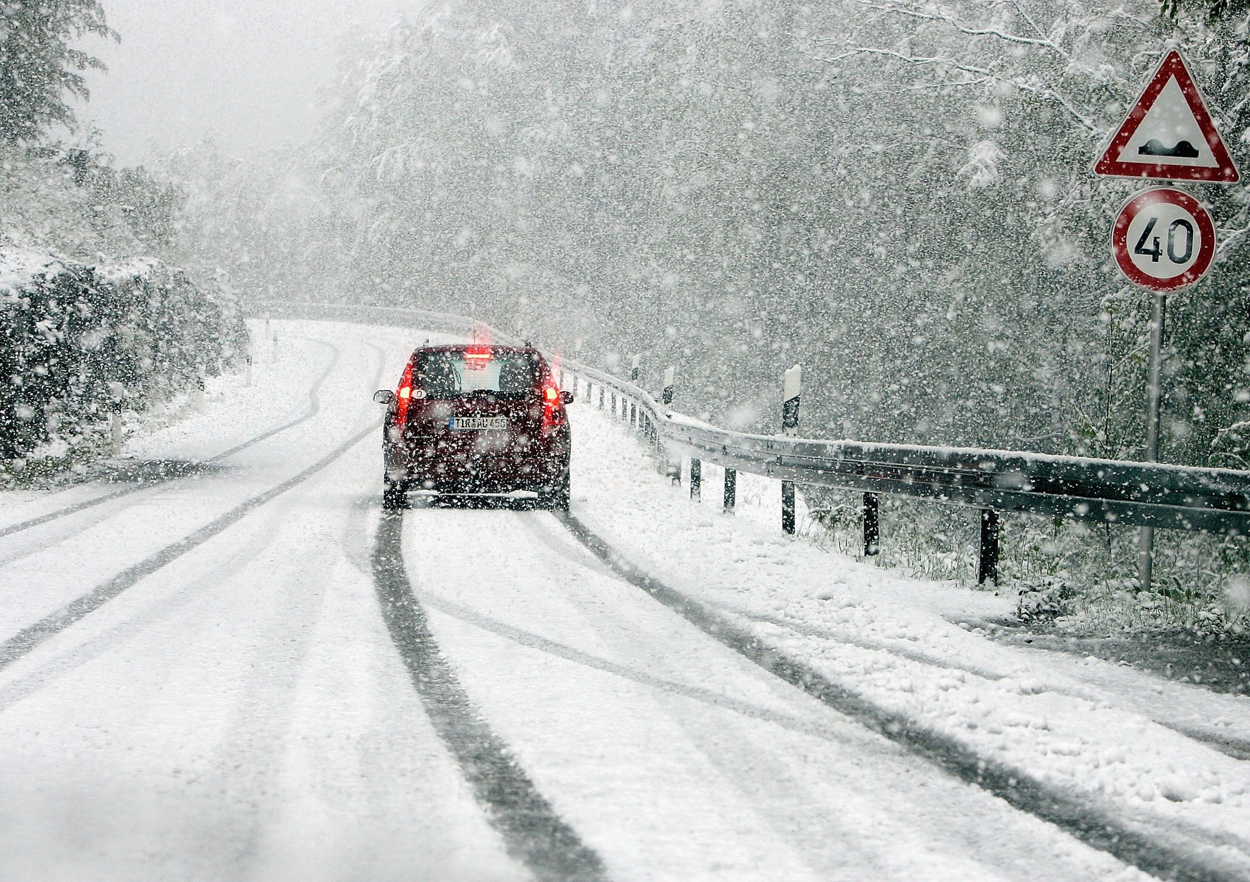 Winter Driving 101: A car drives down a snowy road