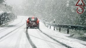 Winter Driving 101: A car drives down a snowy road