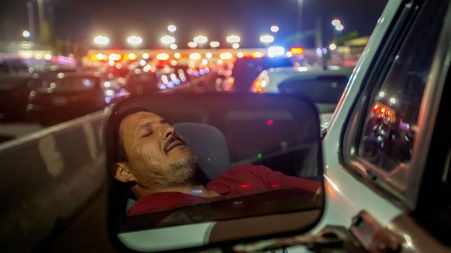 A man sleeping/passed out behind the wheel during a traffic stop slowdown in Tijuana, Mexico