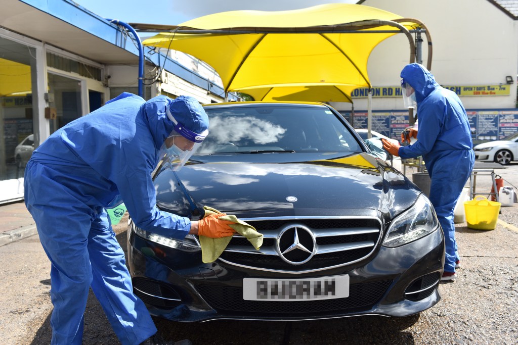 Workers wash cars wearing full protection against Coronavirus. 