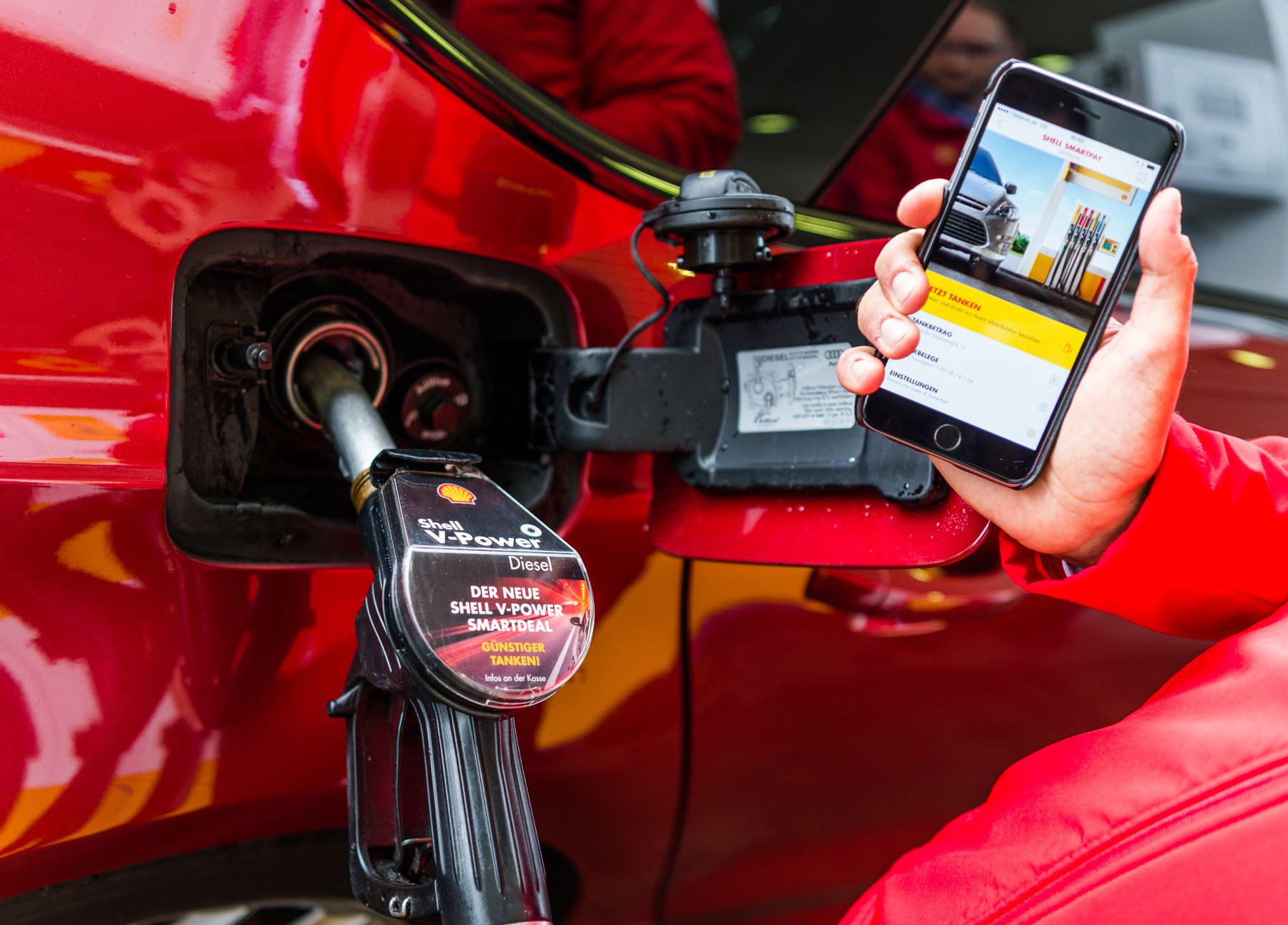 A man filling up his tank using a gas station app at a Shell station