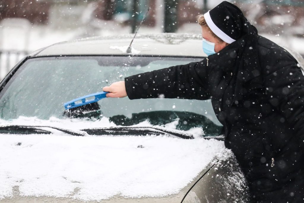 A nun clearing snow off a car windshield during winter in Krakow, Poland video proof shows why its a good idea