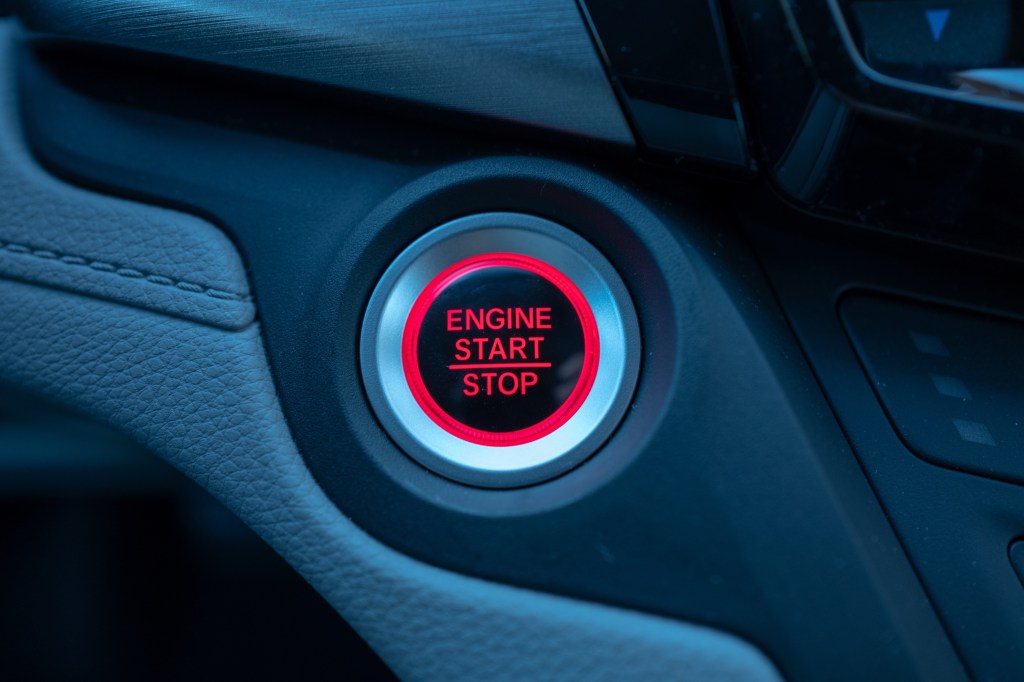 Close-up of engine start and stop button on the dashboard of a car.