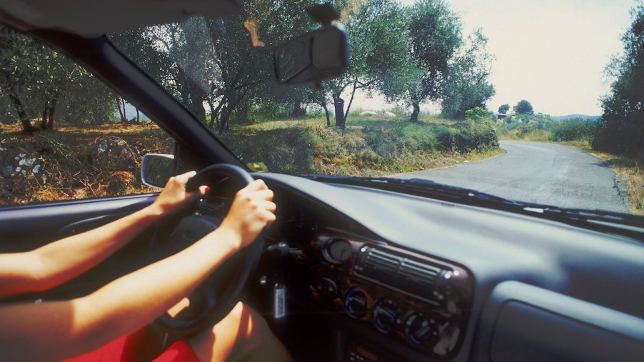 A woman's hands on a steering wheel while driving in Ibiza, Spain, in 2004