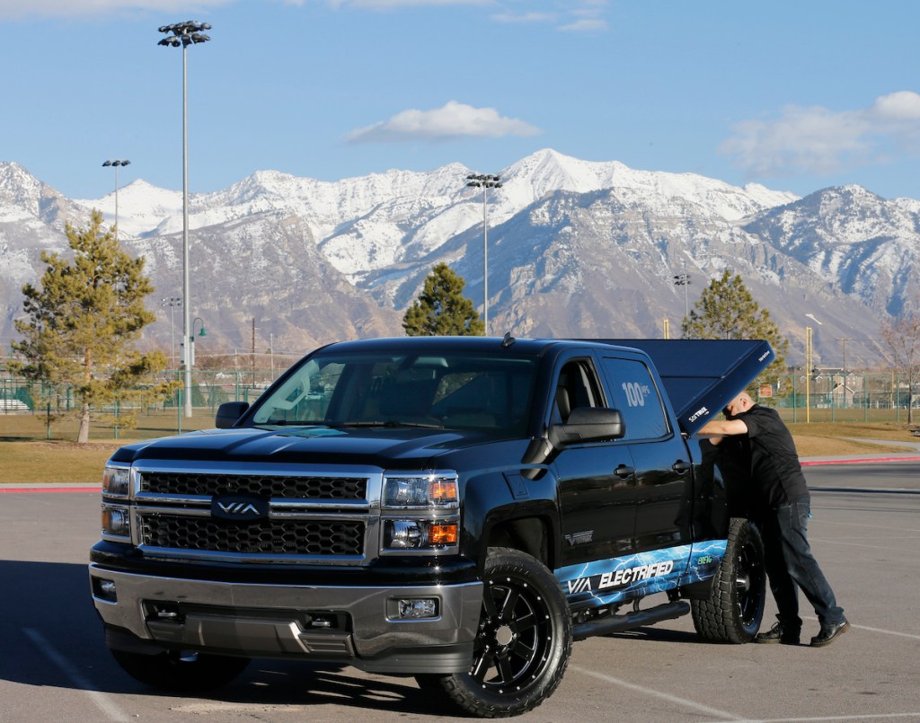 A man lifts a tonneau cover on a Chevy pickup truck in 2005 in Orem, Utah