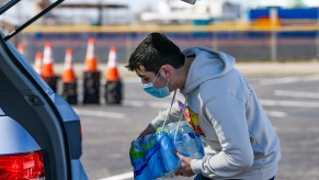 A man places water bottles into the back of a car in winter 2021 in Galveston, Texas