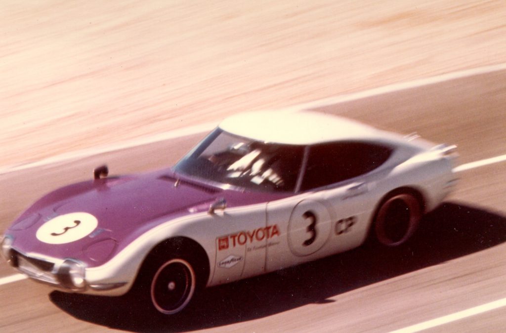 A white-and-blue 1968 Toyota 2000GT racing in a Las Vegas SCCA event