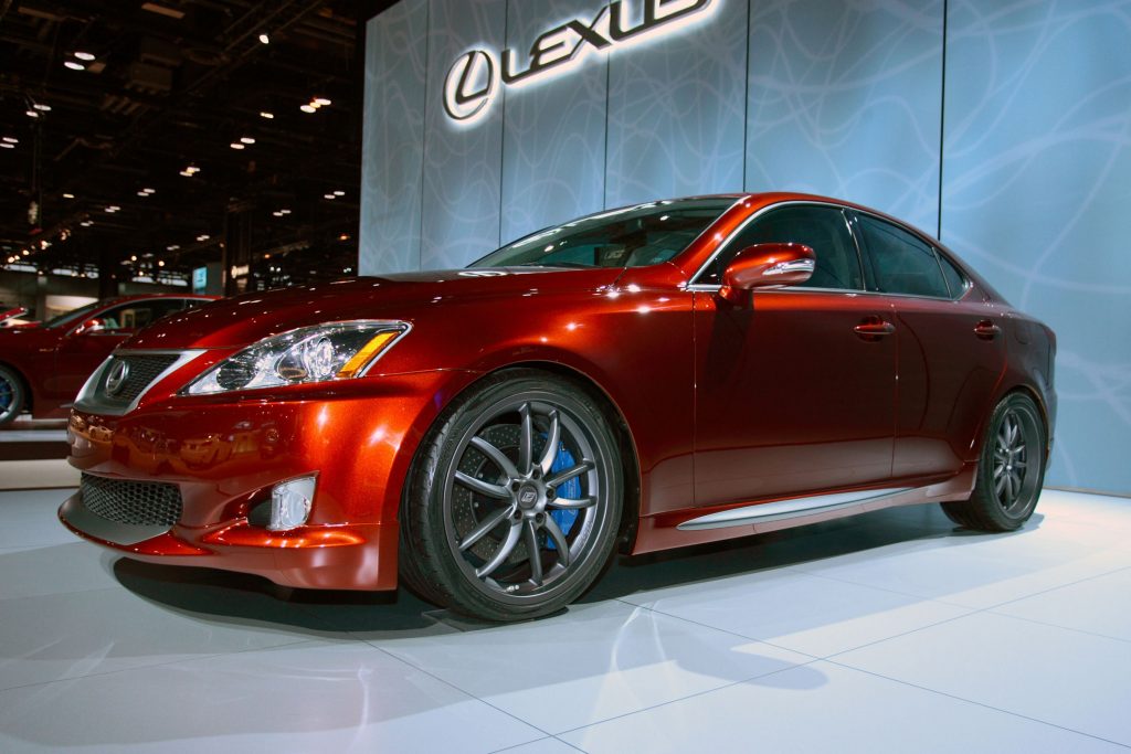 A red 2009 Lexus IS 350 with F-Sport accessories on an auto show stage