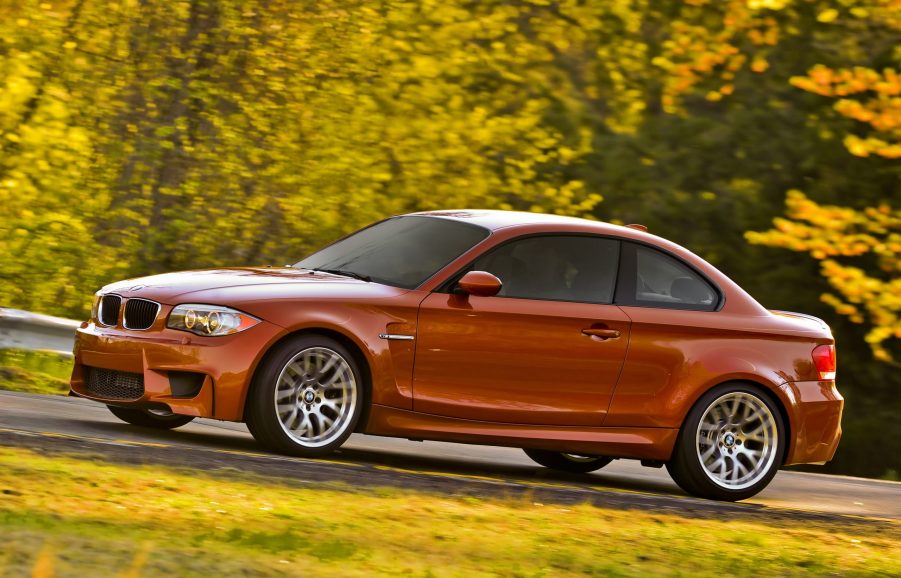 An orange 2011 BMW 1 Series M Coupe on a country road