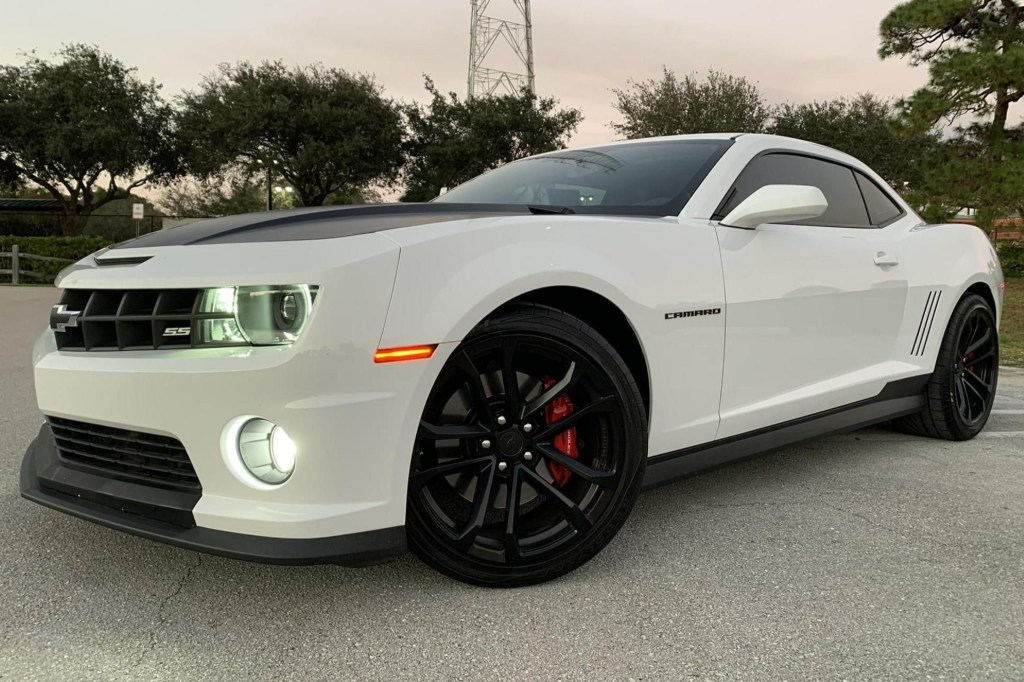 The front 3/4 view of a white-and-black 2013 Chevrolet Camaro SS 1LE