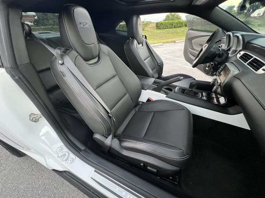 The black-leather-upholstered interior of a white 2013 Chevrolet Camaro SS 1LE