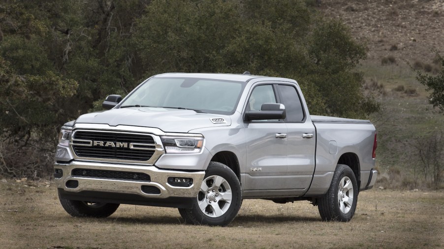 Silver 2019 Ram 1500 parked in a field. This fifth-generation pickup truck wears a Big Horn badge.
