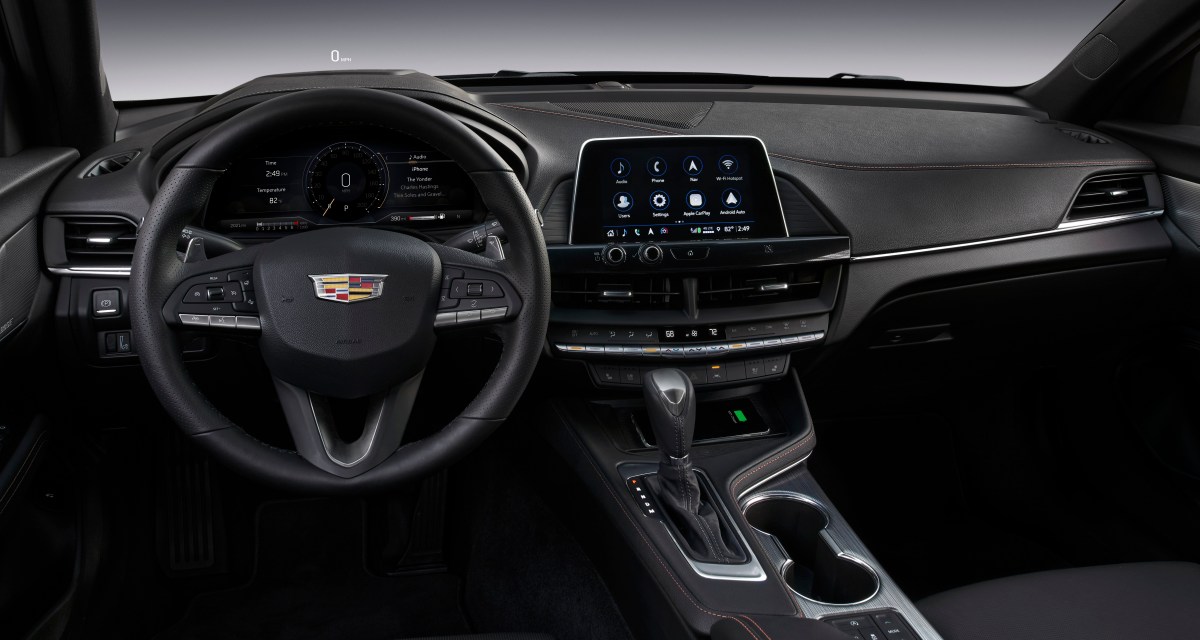 A view of the interior of a 2021 Cadillac CT4 showing the steering wheel, instrument cluster, dashboard, and infotainment system.