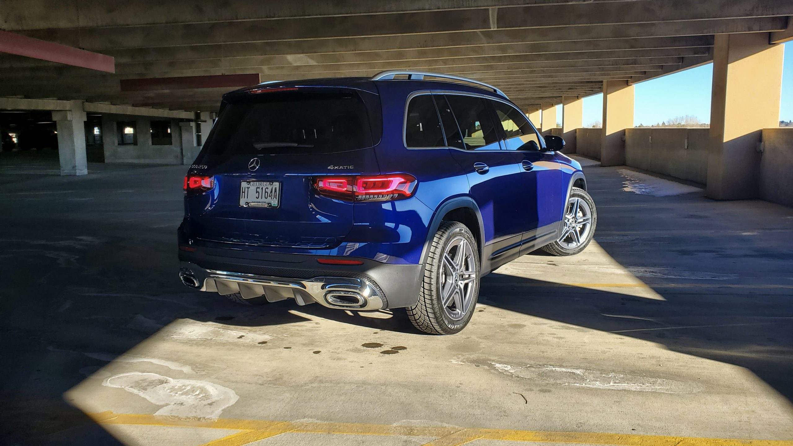 A rear 3/4 shot of a blue GLB 250 in a parking garage