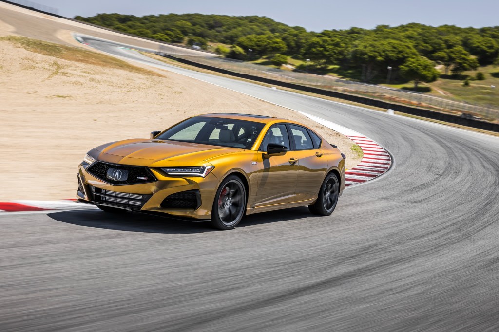 A 3/4 front view of a gold 2021 Acura TLX Type-S cornering on a race track