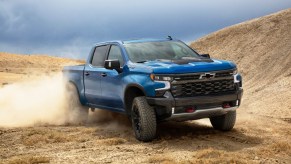 A blue 2022 Chevy Silverado ZR2 is a better buy than the Ford Raptor or Ram TRX pickup trucks
