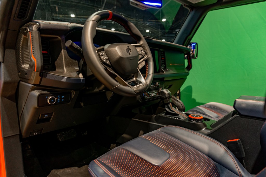 The black-and-orange front seats and dashboard of a 2022 Ford Bronco Raptor at the 2022 Chicago Auto Show