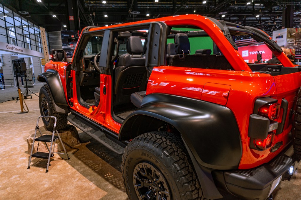 The rear 3/4 view of an orange 2022 Ford Bronco Raptor at the 2022 Chicago Auto Show