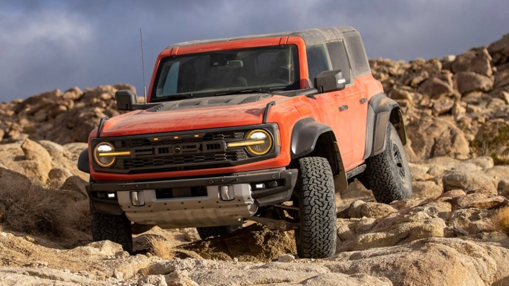 Orange 2022 Ford Bronco Raptor on a rocky trail