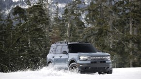 A gray 2022 Ford Bronco Sport crossover SUV drives in the snow in the wildnerness