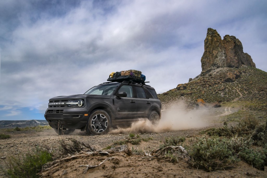 The 2022 Ford Bronco Sport compact crossover SUV driving through the wilderness with a roof rack full of cargo