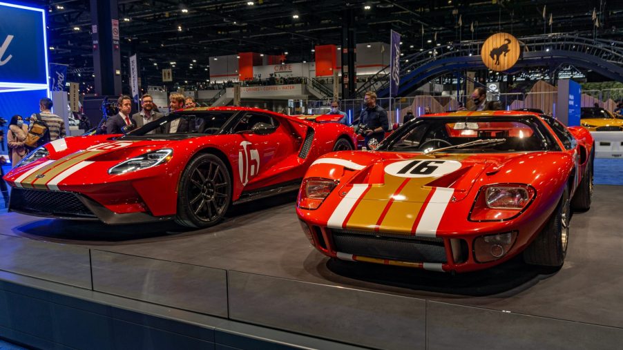 A red-and-gold 2022 Ford GT Alan Mann Heritage Edition next to the red-and-gold 1966 Ford GT40 Mk I Lightweight 'AM GT-1' on a stand