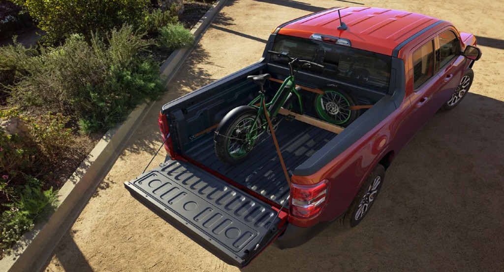 A red 2022 Ford Maverick Flexbed is carrying a bike. 