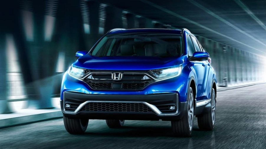 A blue 2022 Honda CR-V small SUV is driving on the road.