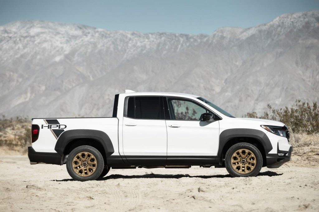 The 2022 Honda Ridgeline Sport with HPD Package unibody pickup truck with a white paint color parked in a mountain desert