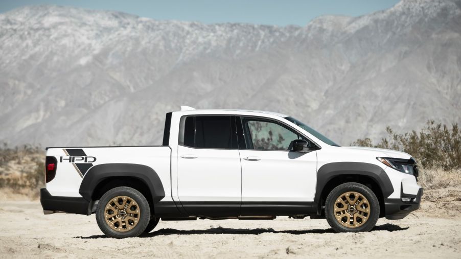 The 2022 Honda Ridgeline Sport with HPD Package unibody pickup truck with a white paint color parked in a mountain desert