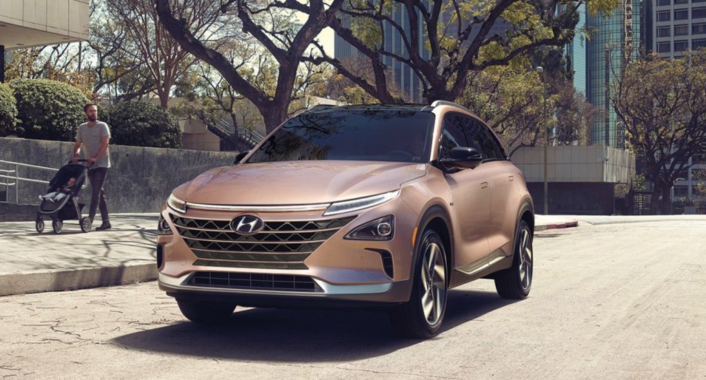 A copper metallic 2022 Hyundai Nexo compact SUV is driving on the road. 