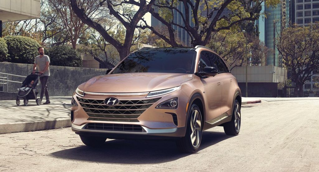 A copper metallic 2022 Hyundai Nexo compact SUV is driving on the road.