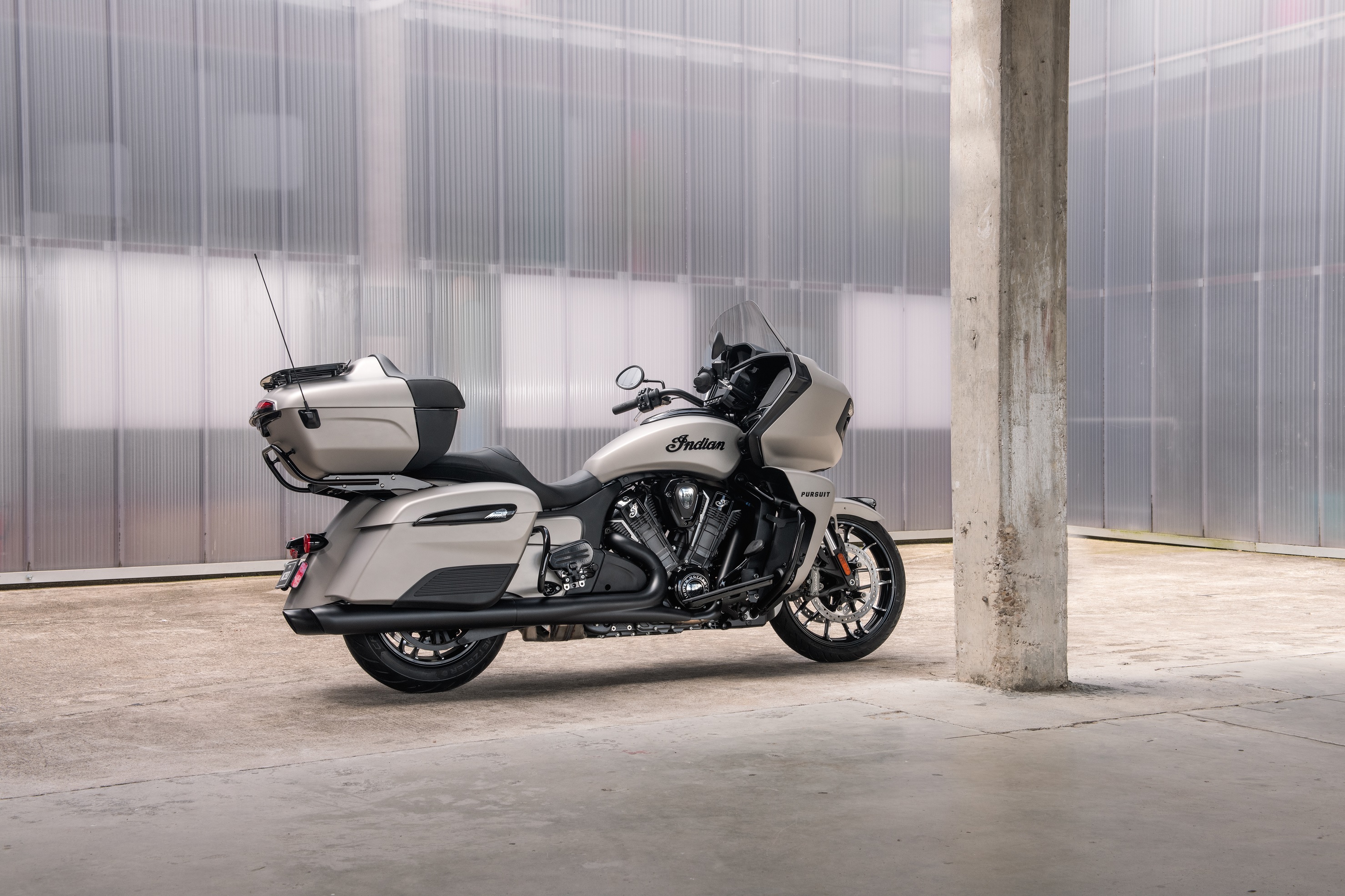 The side 3/4 view of a white 2022 Indian Pursuit Dark Horse in a garage