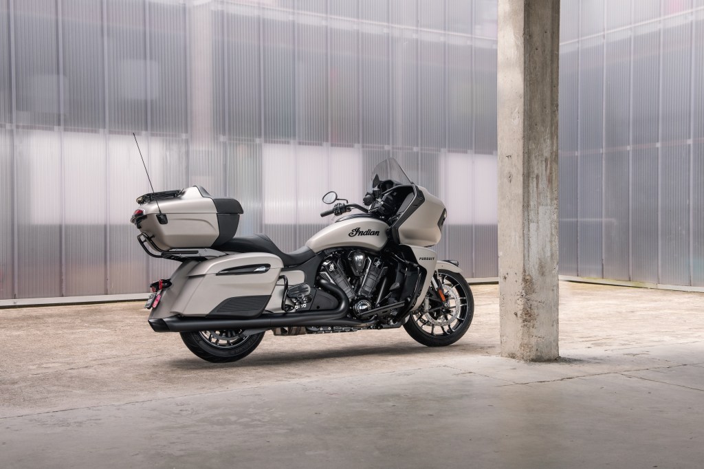 The side 3/4 view of a white 2022 Indian Pursuit Dark Horse in a garage