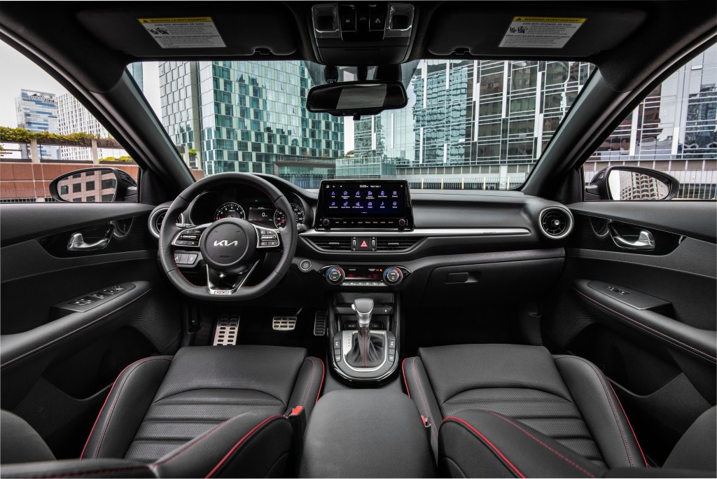 The red-stitched faux-black-leather front seats and black dashboard of a 2022 Kia Forte GT