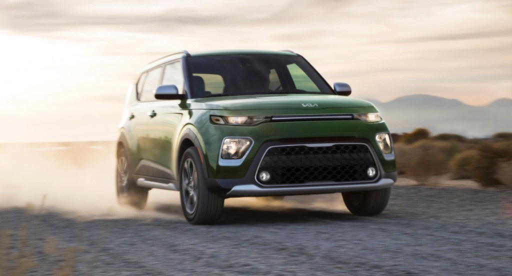 A green 2022 Kia Soul subcompact SUV is driving off-road.