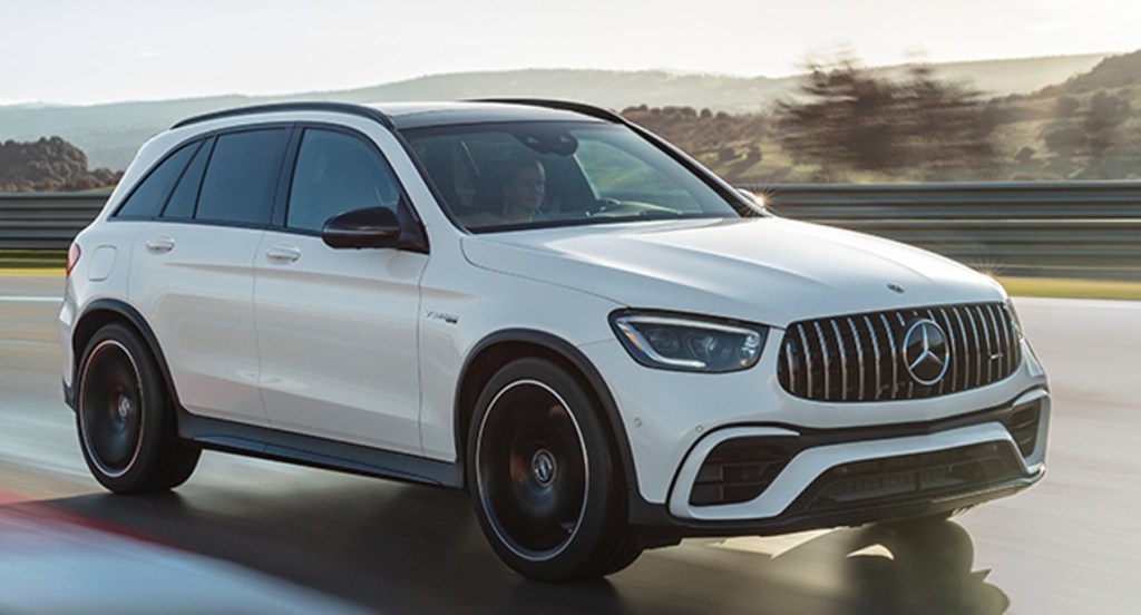A white 2022 Mercedes-Benz AMG GLC 63 S luxury SUV is driving on the road.
