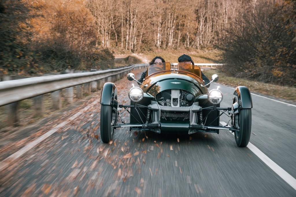 The front of a dark-green 2022 Morgan Super 3 on a road