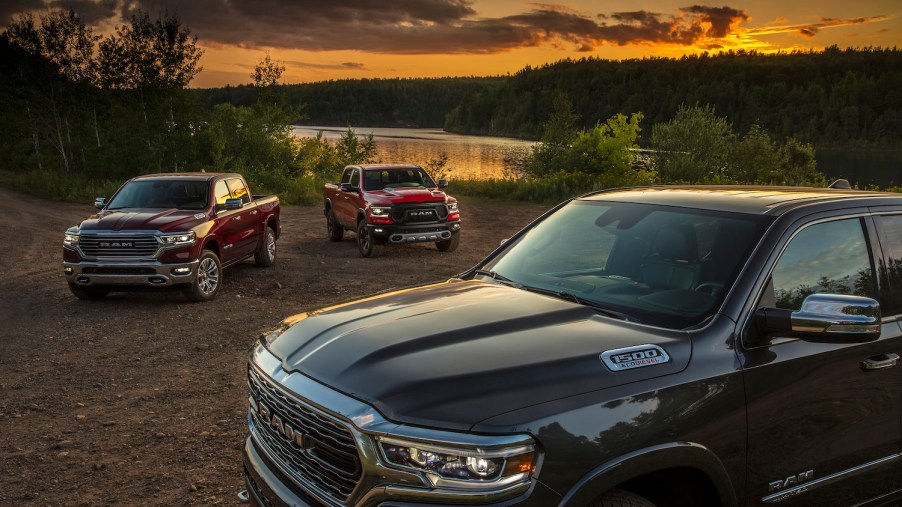 Promo of three 2022 Ram 1500 trucks in front of a pond, EcoDiesel engine badges on display.