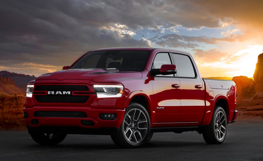Promo shot of a red Ram 1500 Laramie G/T muscle truck parked in front of a sunset in the desert.