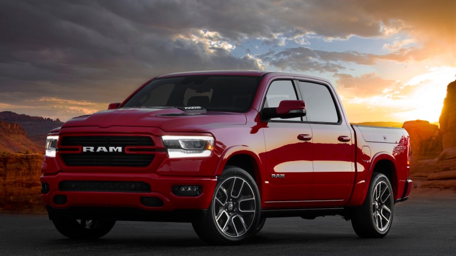 Promo shot of a red Ram 1500 Laramie G/T muscle truck parked in front of a sunset in the desert.