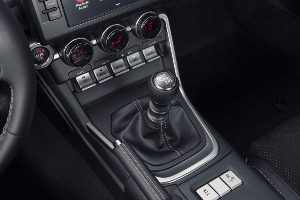 The manual transmission shifter in the black center console of a 2022 Toyota GR86 Premium